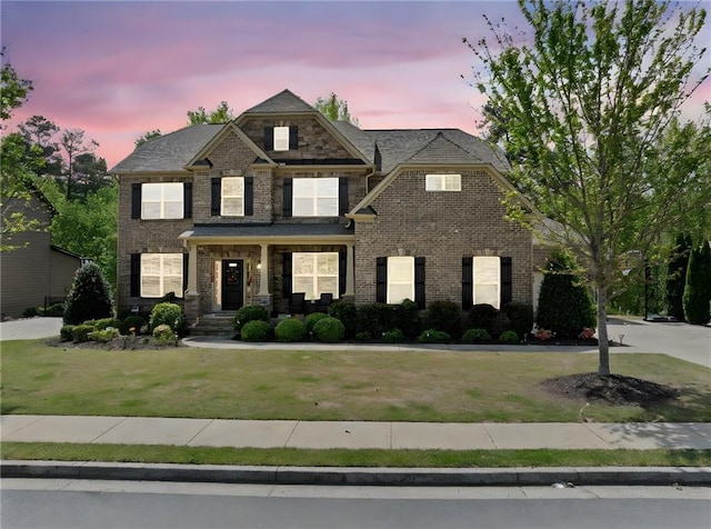 view of front facade with a front lawn and brick siding
