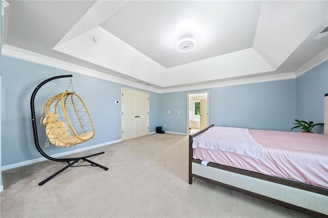 carpeted bedroom featuring a tray ceiling, crown molding, and baseboards