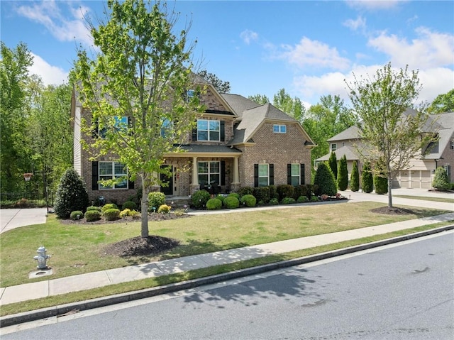 craftsman inspired home with brick siding and a front yard