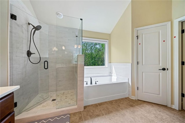 bathroom with a garden tub, a stall shower, vaulted ceiling, and vanity