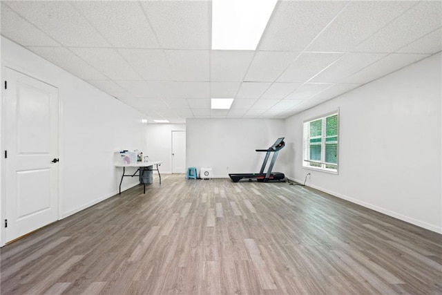 workout area with a drop ceiling, baseboards, and wood finished floors