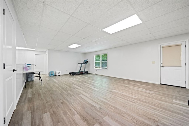 exercise room with wood finished floors, baseboards, and a drop ceiling