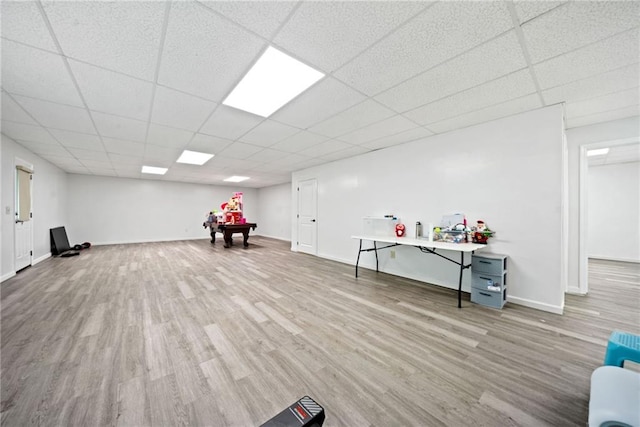 interior space with wood finished floors, baseboards, and a drop ceiling