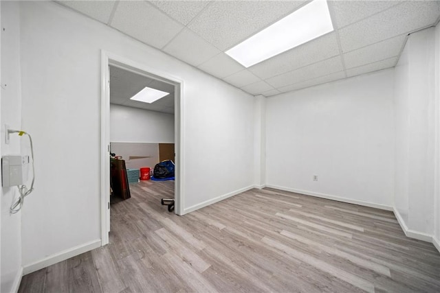 unfurnished room featuring a paneled ceiling, wood finished floors, and baseboards