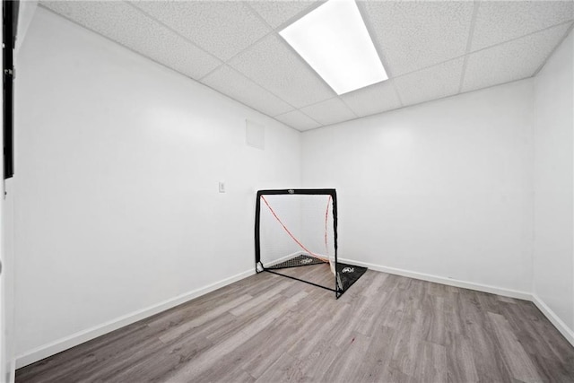 interior space with a paneled ceiling, wood finished floors, and baseboards