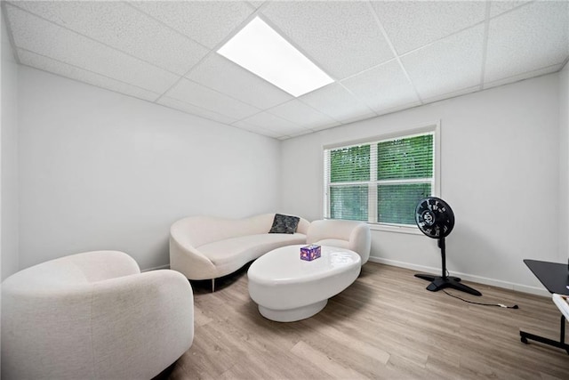 bedroom featuring baseboards, a paneled ceiling, and wood finished floors