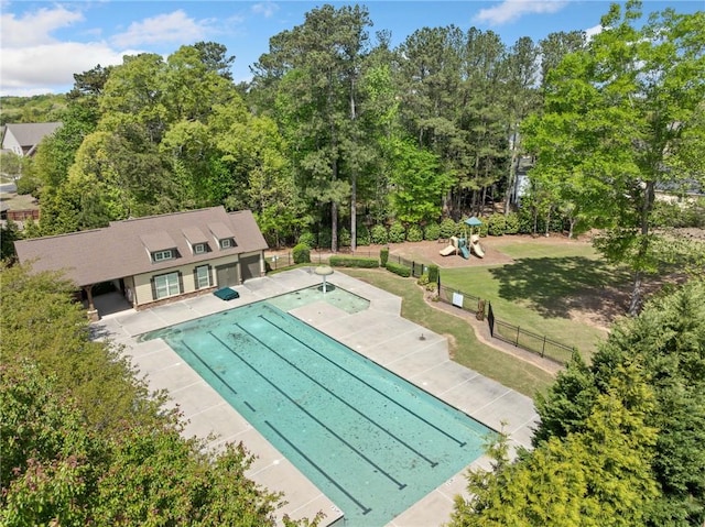 community pool featuring a patio, playground community, fence, and a lawn