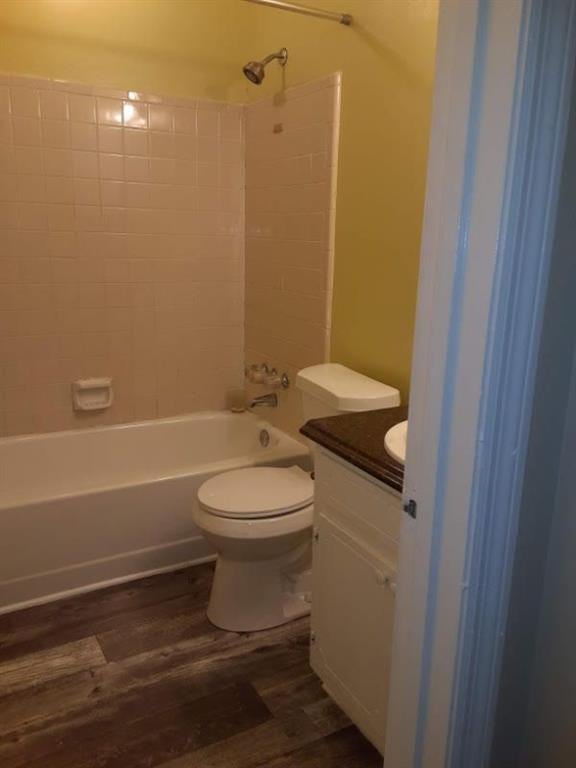 full bathroom featuring vanity, wood finished floors, toilet, and shower / washtub combination