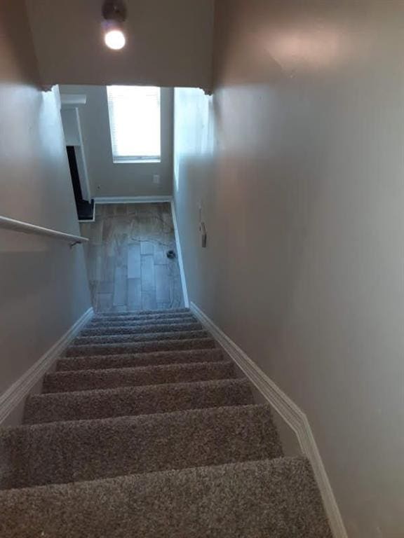 staircase with carpet floors and baseboards