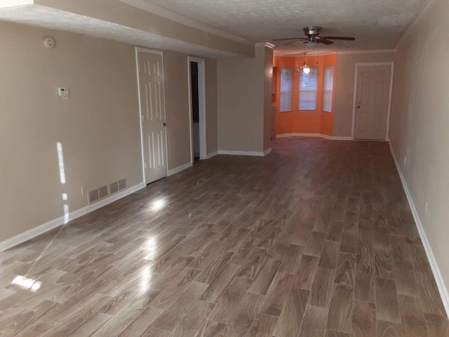 empty room with baseboards, a ceiling fan, wood finished floors, and visible vents