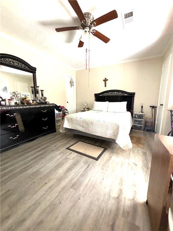 5687 Pine Meadow Ct, Morrow, GA 30260 - bedroom with visible vents, wood finished floors, ornamental molding, and a ceiling fan