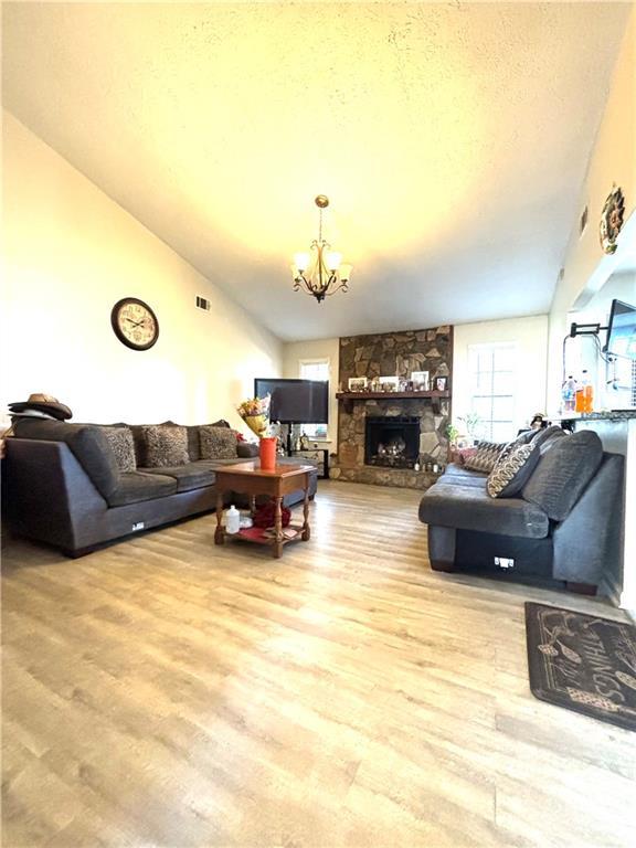 5687 Pine Meadow Ct, Morrow, GA 30260 - living room with an inviting chandelier, a wealth of natural light, a textured ceiling, and wood finished floors