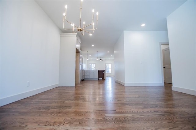 unfurnished living room with baseboards, ceiling fan with notable chandelier, wood finished floors, and recessed lighting