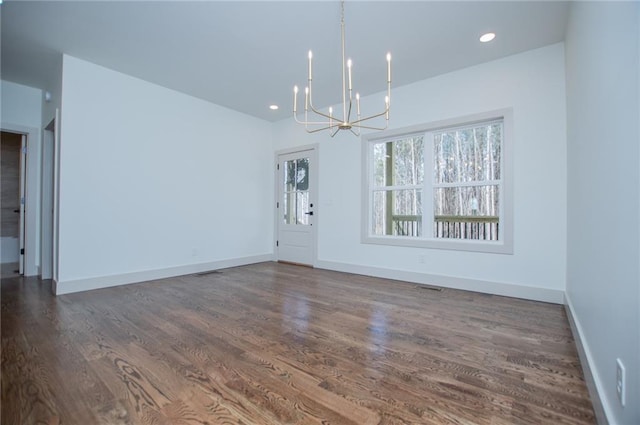 unfurnished dining area featuring recessed lighting, visible vents, dark wood-type flooring, a chandelier, and baseboards