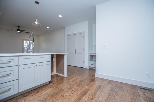 kitchen featuring recessed lighting, visible vents, light countertops, light wood finished floors, and decorative light fixtures