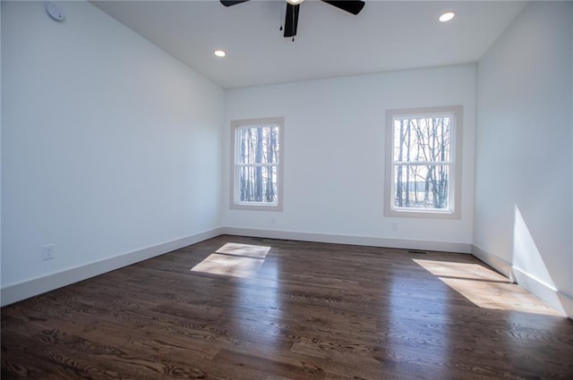 unfurnished room featuring a wealth of natural light, dark wood finished floors, baseboards, and recessed lighting