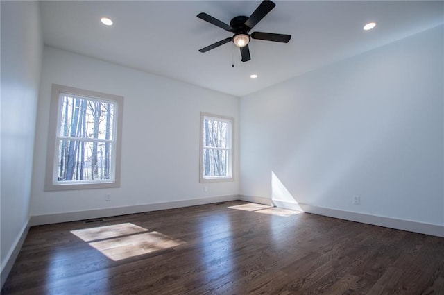 unfurnished room with wood finished floors, a wealth of natural light, and baseboards