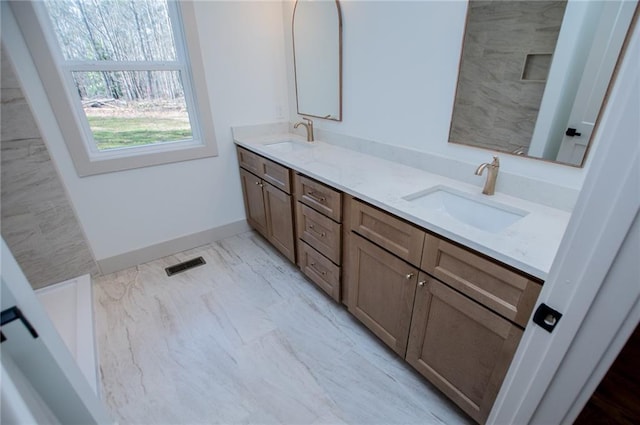 full bathroom with double vanity, marble finish floor, visible vents, and a sink