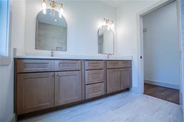 bathroom featuring double vanity, baseboards, and a sink