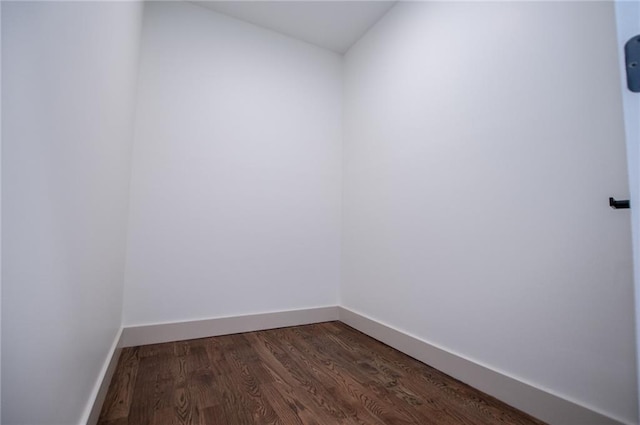 spare room featuring dark wood-style floors and baseboards