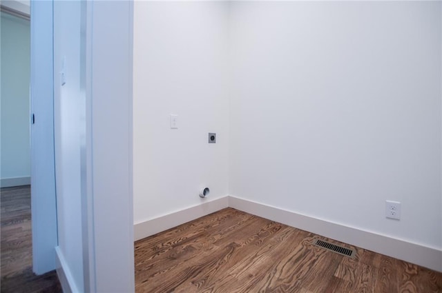 laundry area with laundry area, visible vents, baseboards, dark wood-type flooring, and electric dryer hookup