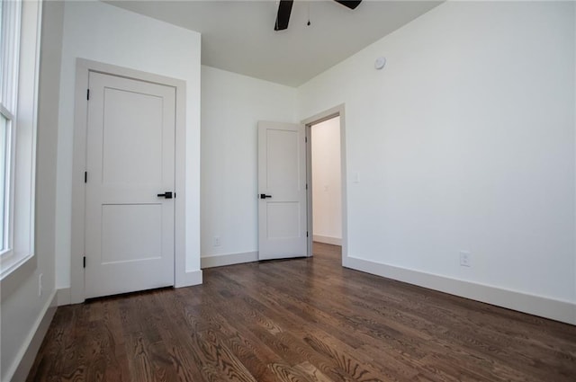 unfurnished bedroom with baseboards, dark wood finished floors, and a ceiling fan