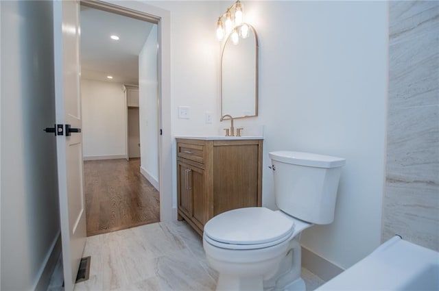 bathroom featuring toilet, recessed lighting, baseboards, and vanity