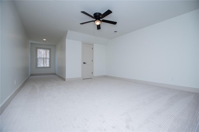 spare room with light carpet, visible vents, baseboards, and a ceiling fan