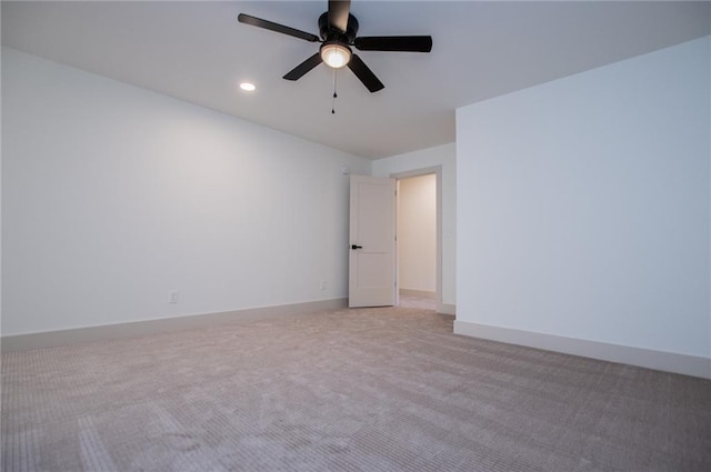 spare room featuring light carpet, ceiling fan, recessed lighting, and baseboards