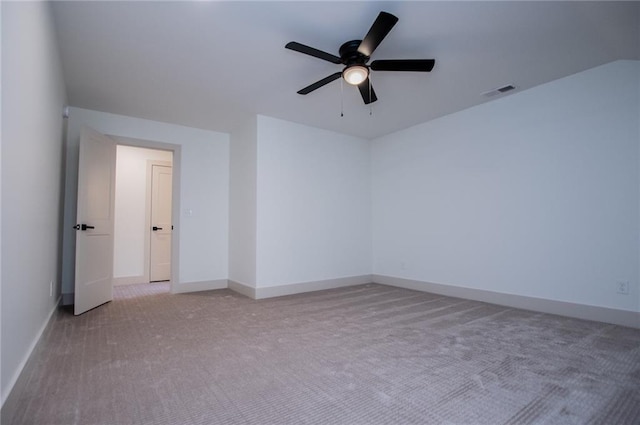 unfurnished room with light carpet, a ceiling fan, visible vents, and baseboards