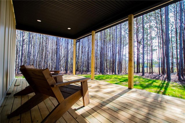 deck with a forest view and a lawn