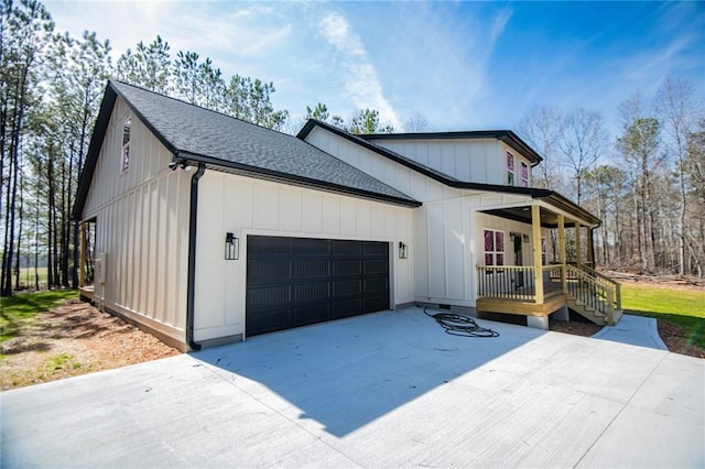 exterior space with a garage, board and batten siding, a shingled roof, and concrete driveway