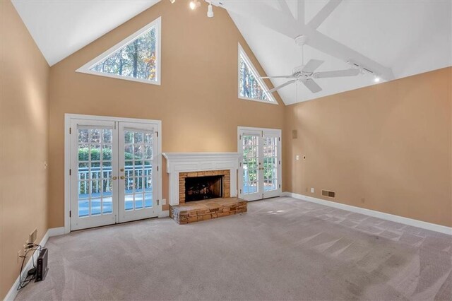 unfurnished living room featuring a healthy amount of sunlight, rail lighting, and french doors