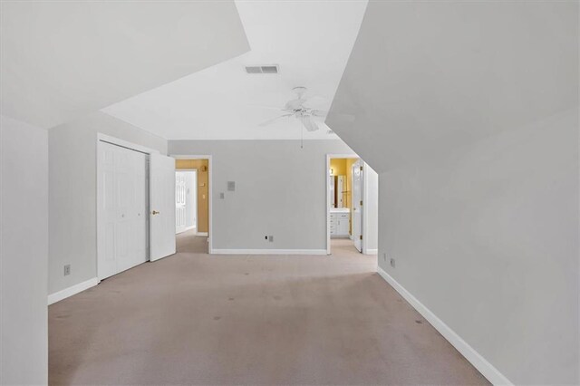 additional living space featuring light colored carpet, ceiling fan, and lofted ceiling