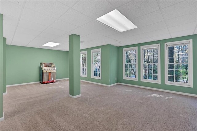 interior space featuring a paneled ceiling and light colored carpet