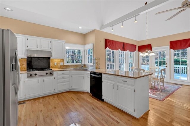 kitchen featuring kitchen peninsula, light stone countertops, light wood-type flooring, white cabinetry, and stainless steel appliances