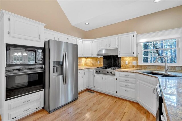 kitchen featuring black appliances, white cabinets, sink, decorative backsplash, and light hardwood / wood-style floors