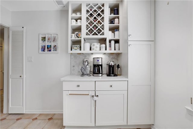 bar with decorative backsplash, baseboards, and visible vents