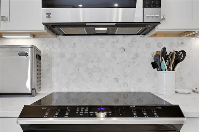 kitchen featuring stainless steel microwave, white cabinets, and electric range oven