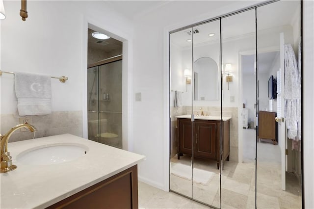 bathroom with a stall shower, vanity, and ornamental molding