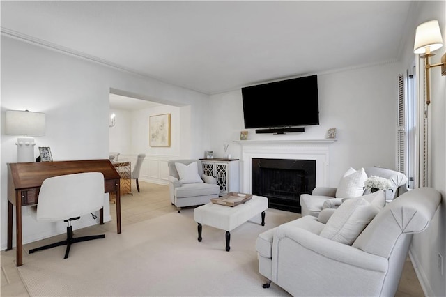 living room featuring ornamental molding, a fireplace, and a decorative wall