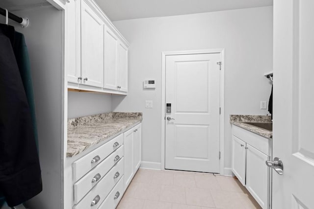 laundry area with baseboards and a sink