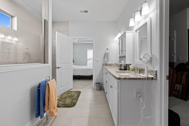 bathroom featuring a sink, tiled shower, visible vents, and connected bathroom