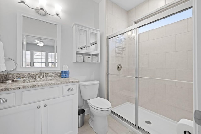 full bathroom featuring a ceiling fan, vanity, toilet, and a shower stall