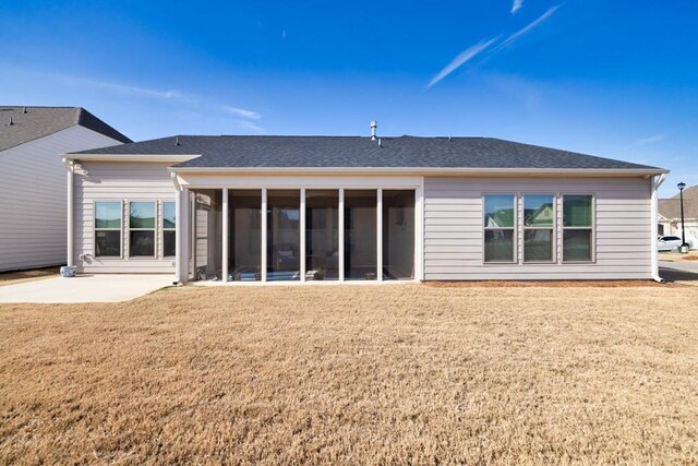 back of house featuring a patio, a lawn, a sunroom, and roof with shingles