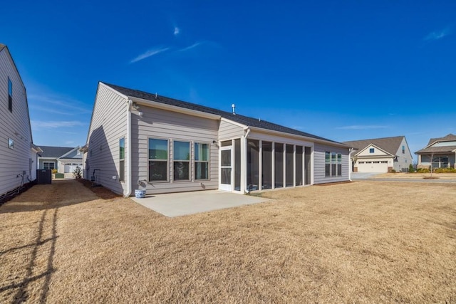 back of property featuring a patio area, a lawn, and a sunroom