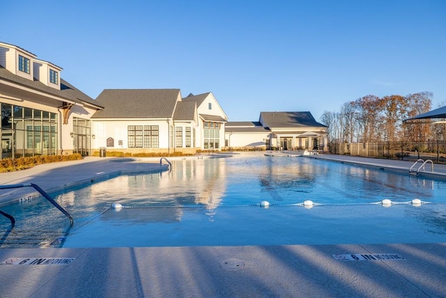 community pool with a patio and fence