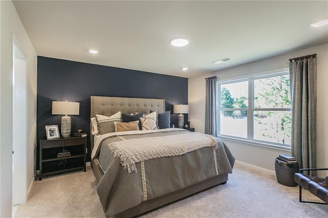 bedroom with light colored carpet, visible vents, and baseboards