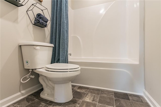 bathroom featuring toilet, baseboards, and shower / bath combination with curtain