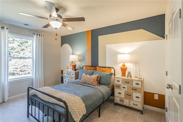 bedroom with baseboards, a ceiling fan, visible vents, and light colored carpet